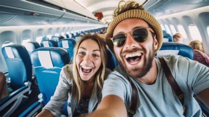 a man and woman taking a selfie in front of a television screen with