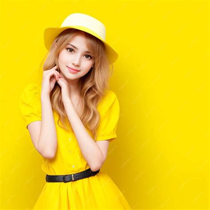 a woman wearing a yellow dress with long sleeves and high neck