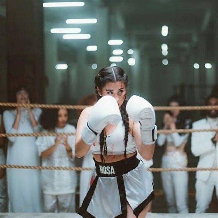 a woman wearing white boxing gloves posing for a photo with her hands