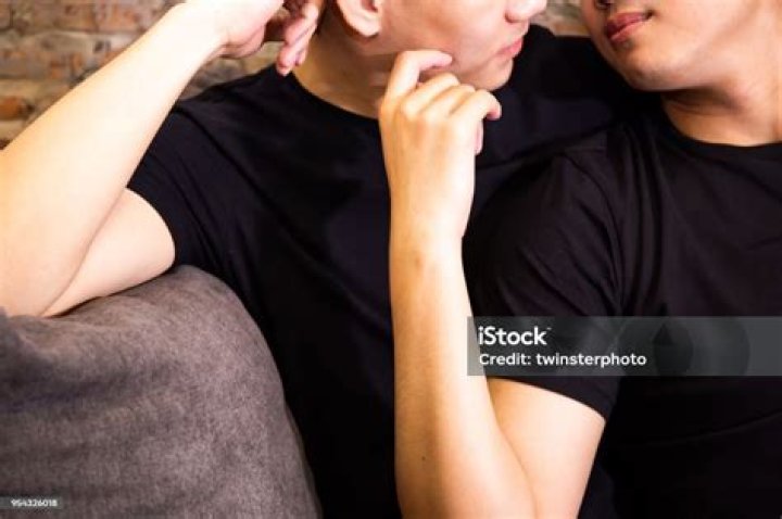 Asian gay couple looking at each other together at vintage home