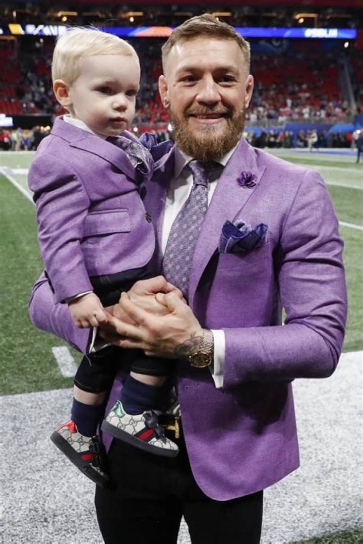 Conor McGregor and toddler son wear matching purple suits as they walk