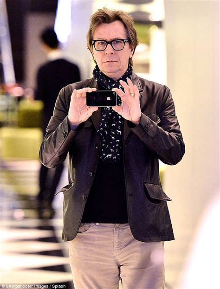 Gary Oldman maintains his ice cool image as he takes sons and wife