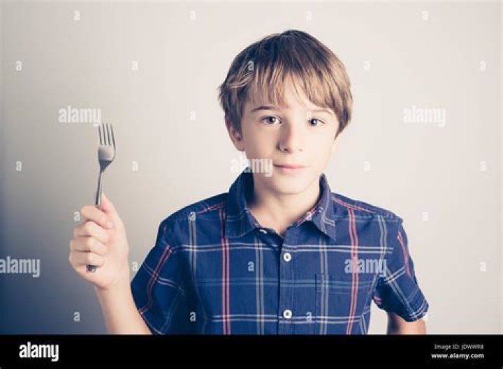 little boy with fork ready to eat filtered retro style Stock Photo