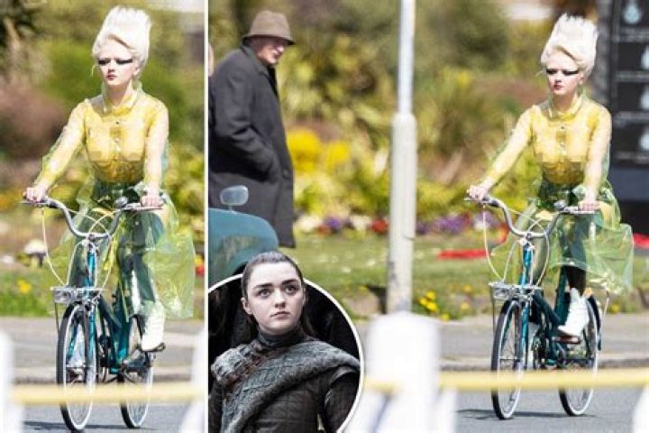Maisie Williams rides a bike wearing a seethrough mac and no bra as