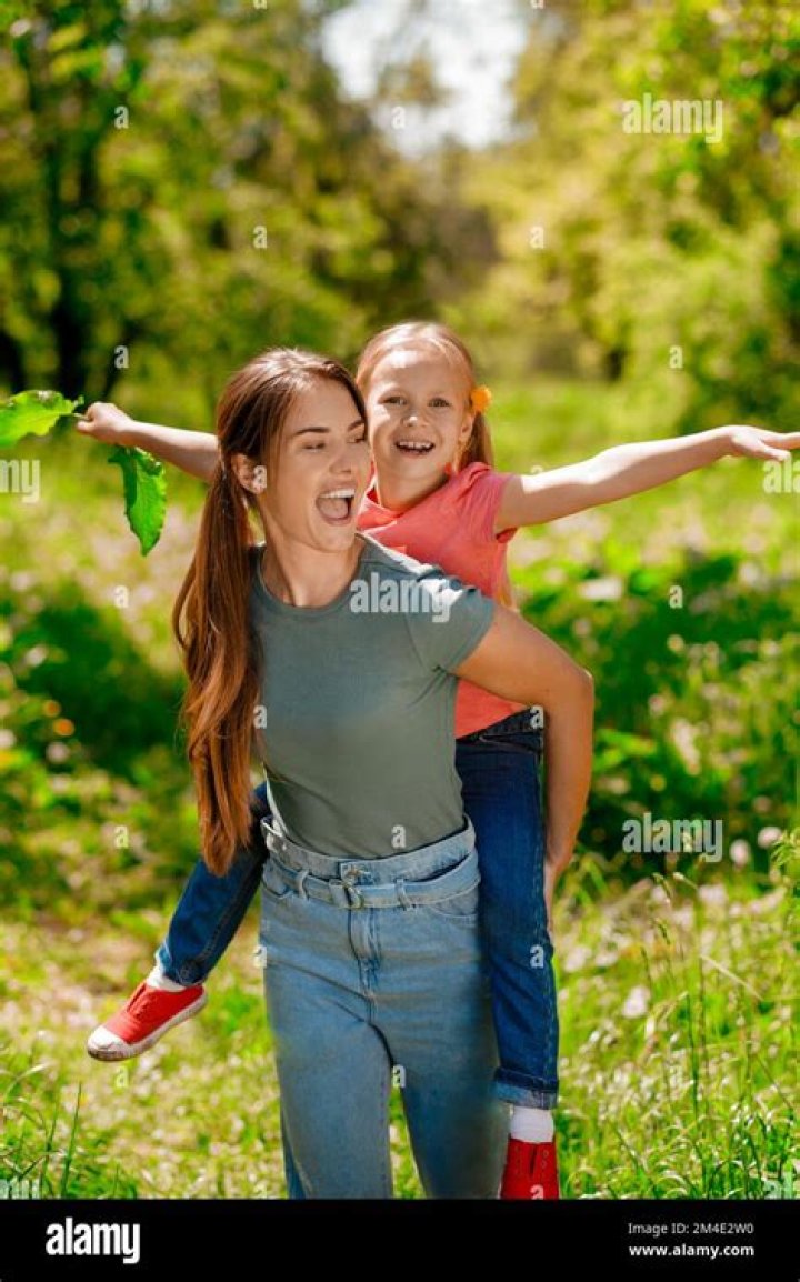 Mom Carrying Her Kid on Her Back and Both Feeling Amazing Stock Image