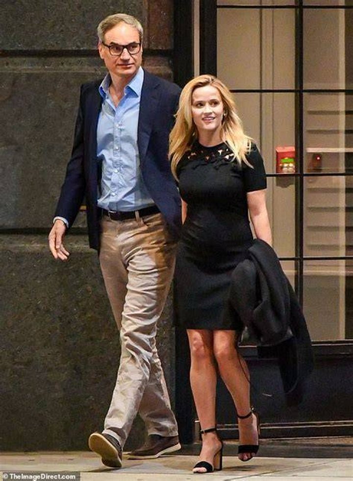 Reese Witherspoon beams eartoear in a denim skirt as she films Your