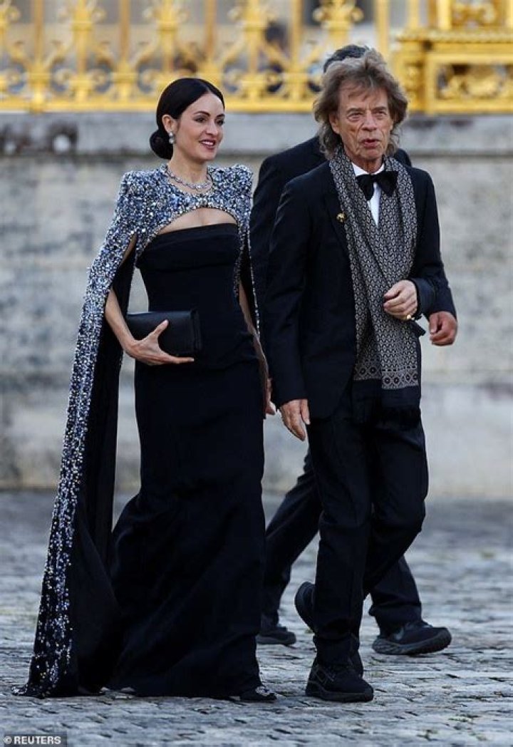 Sir Mick Jagger, 80, battles strong winds as he arrives at King Charles