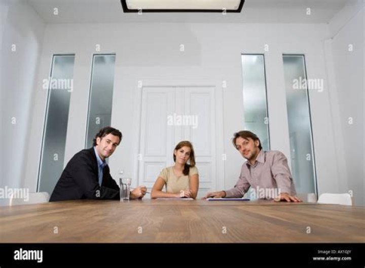 three people sitting at a table with food in front of them and one